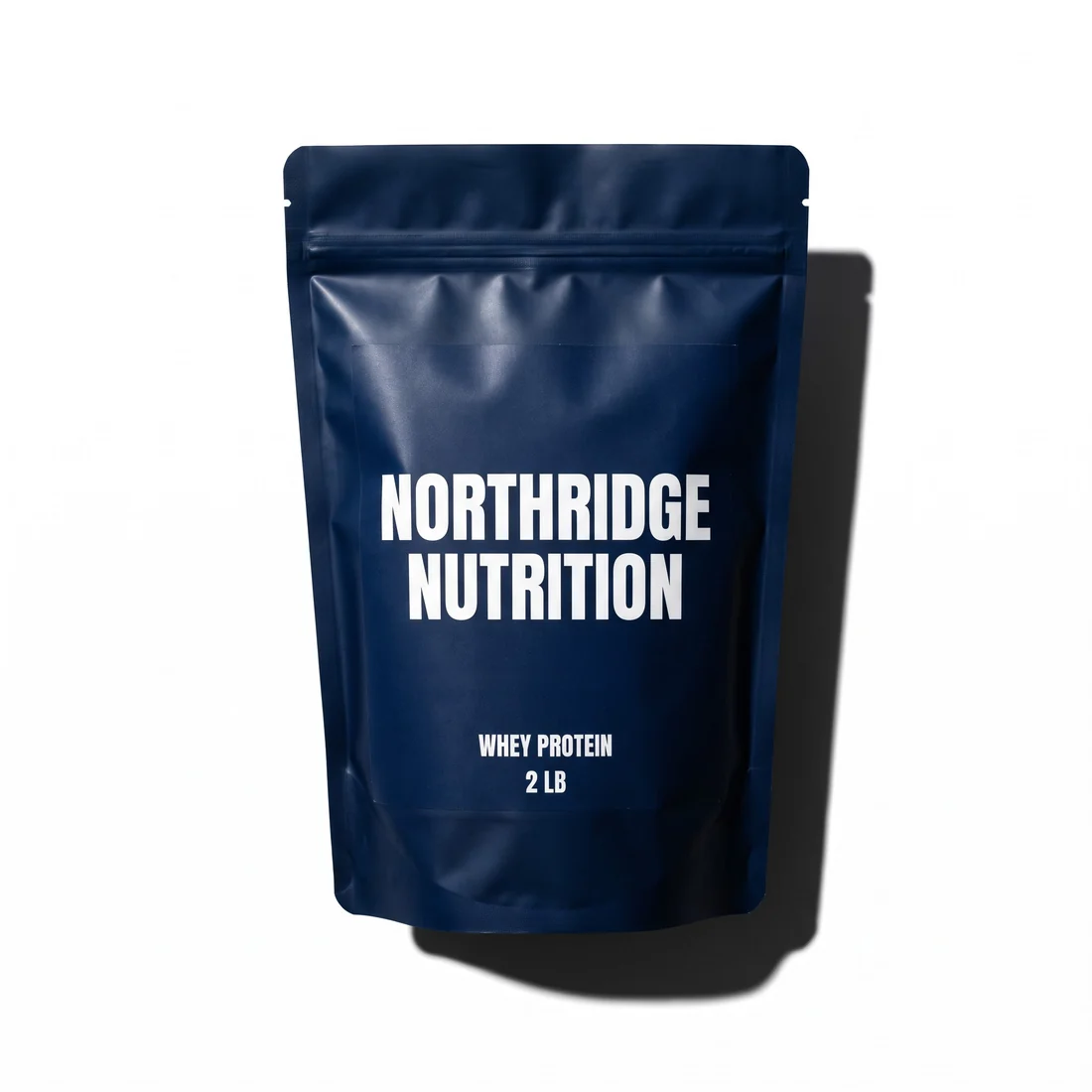 Concept standup zipper pouch for a US sports nutrition brand, matte navy with a white wordmark